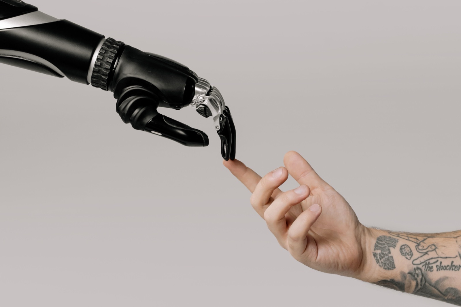 Een mensenhand reikt naar een robothand, symbool voor mens-robotsamenwerking
